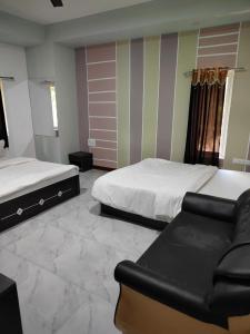 萨三吉尔the levels home的一间卧室配有两张床和一张沙发。