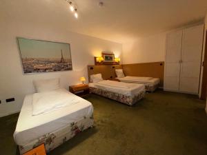 a hotel room with two beds and a painting on the wall at Yeti City Hotel Saarbrücken in Saarbrücken