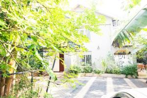 una casa bianca con cortile alberato di Mirembe Villas Kigo a Kigo
