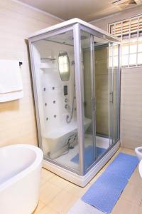 un bagno con doccia, WC e vasca di Mirembe Villas Kigo a Kigo