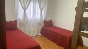 twee bedden in een kamer met een raam bij Casa piscina in Poços de Caldas