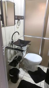 een badkamer met toilet en wastafel bij Casa piscina in Poços de Caldas