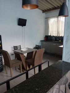 een keuken en eetkamer met een tafel en stoelen bij Casa piscina in Poços de Caldas
