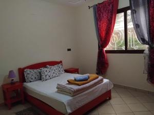 a bedroom with a bed and a window with red curtains at Modern villa with pool in Mirleft