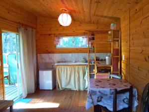 a kitchen in a log cabin with a table at Chalets rustiques en pleine nature, L'ARCHIPEL in Punta Del Diablo +17 photos