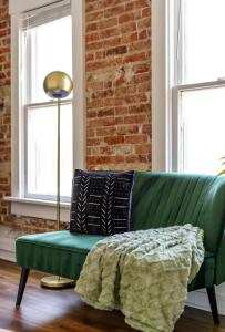 a green couch in a room with a brick wall at Parking Free - Short North - Convention - Pets in Columbus