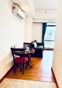 una sala de estar con una mesa y un sofá en Maju Suites Berjaya Times Square, en Gua Sai