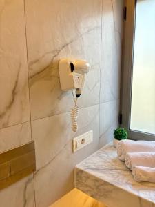 een badkamer met een telefoon op een stenen muur bij Le Gemme Luxury in Zambrone