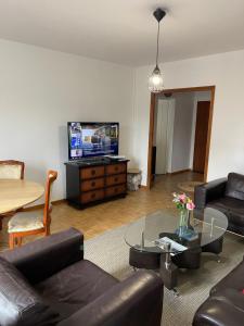 een woonkamer met een bank, een tafel en een tv bij Champs Bernard in Villefranche-de-Rouergue