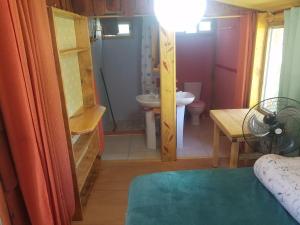 a small bathroom with a sink and a toilet at Chalets rustiques en pleine nature, L'ARCHIPEL in Punta Del Diablo