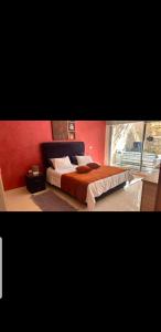 a bedroom with a bed and a red wall at Agadir residence adan beach aourir in Agadir