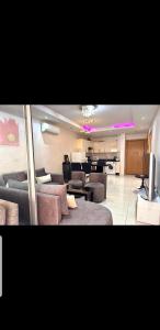 a living room with couches and a television and a kitchen at Agadir residence adan beach aourir in Agadir
