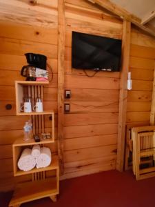 Una habitación con TV y toallas en una cabaña. en La cabaña, en Tlazala de Fabela