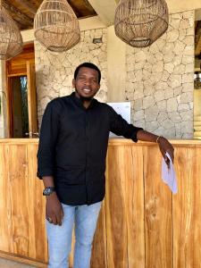 een man die voor een toonbank staat bij GARDEN EDEN Lodge in Jambiani