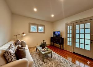 a living room with a couch and a table and a television at Derby and Downtown in Louisville