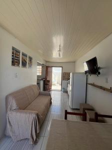 ein Wohnzimmer mit Sofa und Fernseher in der Unterkunft Casa Praia do Hermenegildo in Santa Vitória do Palmar