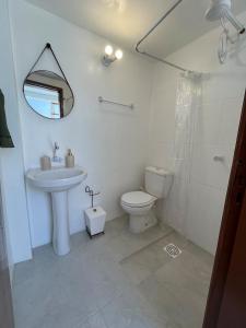 ein Badezimmer mit Waschbecken, Toilette und Spiegel in der Unterkunft Casa Praia do Hermenegildo in Santa Vitória do Palmar