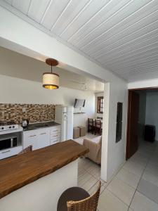 eine Küche und ein Wohnzimmer mit einem Tisch in einem Zimmer in der Unterkunft Casa Praia do Hermenegildo in Santa Vitória do Palmar
