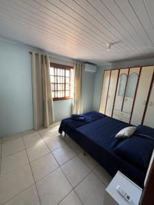 ein Schlafzimmer mit einem blauen Bett und einem Fenster in der Unterkunft Casa Praia do Hermenegildo in Santa Vitória do Palmar + 2 Fotos