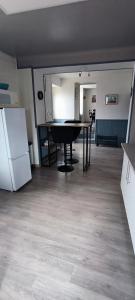 a living room with a table and a refrigerator at La Ville Haute in Chauvigny