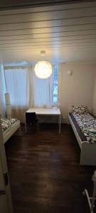 Habitación con 2 camas, ventana y lámpara de araña. en rakentajanpolku 1, en Rovaniemi