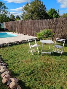 two chairs and a table next to a pool at Refugio Brown in Ciudad Lujan de Cuyo