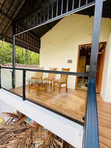 a balcony of a house with chairs and a table at Sanju's Homestay in Attigundi