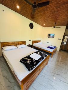a bedroom with two beds in a room at Sanju's Homestay in Attigundi