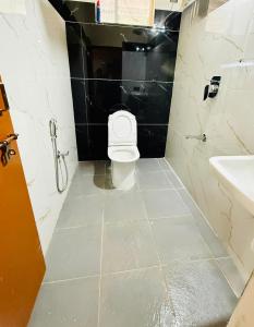 a bathroom with a toilet and a sink at Sanju's Homestay in Attigundi