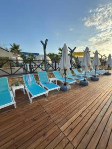 una fila di sedie a sdraio e ombrelloni su una terrazza di Lamoya Suites a Silifke