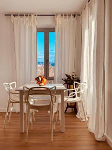 a white dining room with a white table and chairs at La demeure des vignes in Murato