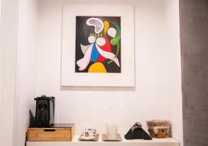 a painting on a wall above a shelf with shoes at ROOMITO apartments in Naples