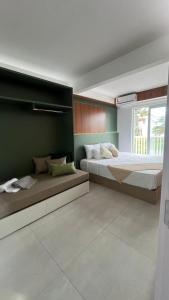 Giường trong phòng chung tại Beira-Mar Sofisticado com Vista Mar e Piscina 02