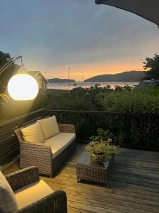 a patio with a couch and chairs on a deck at Lagoon Views in Knysna