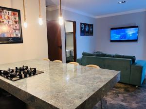 バイーア・フォルモーザにあるCasa Fundo de Quintalのリビングルームに大理石のカウンタートップを備えたキッチン +3枚の写真