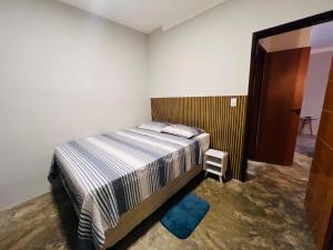 バイーア・フォルモーザにあるCasa Fundo de Quintalのベッドルーム1室(ベッド1台付)、廊下へのドアが備わります。