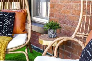 een patio met 2 stoelen en een tafel met een potplant bij Jungle Casa by Jungle House Walkable to High Street Near Nationwide Arena Convention Center & OSU Private Parking Downtown & Short in Columbus