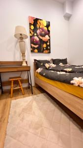 a bedroom with a bed and a lamp and a table at Miodowy apartament in Chorzów