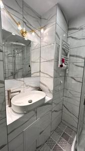 a white bathroom with a sink and a mirror at Miodowy apartament in Chorzów +15 photos