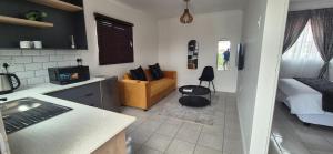 ソウェトにあるFUSH guesthouseのキッチン、リビングルーム(ソファ、ベッド付) +5枚の写真