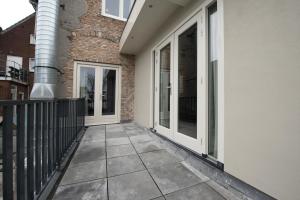 a balcony with sliding glass doors on a building at House of De Swaen Apartments in Breda