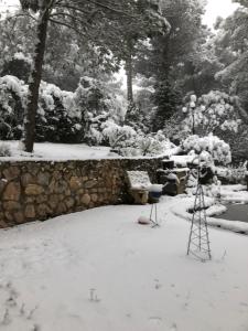 un giardino innevato con un treppiede nel cortile di La Huerta de Chocolate Mínimo 2 años larga duración ad Albalate de Zorita