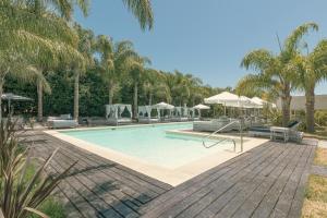 Skyblue Apart Hotel Punta Colorada في بيريابوليس: مسبح بالنخيل والمظلات