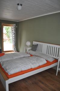 a bedroom with a large white bed with a window at Holzmichel in Friedrichroda