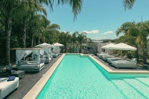 a swimming pool with lounge chairs and umbrellas at Skyblue Park in Piriápolis