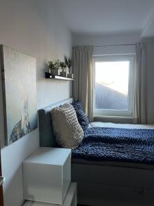 a small bedroom with a bed and a window at Alpenblick - Zentralgelegene 2-Zimmer-Wohnung in Kiefersfelden