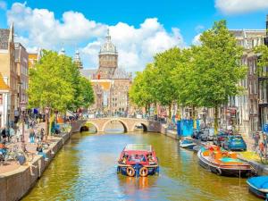 a boat traveling down a river in a city at 3 bedrooms Family House till 6 p Near Amsterdam & Sea in Opmeer