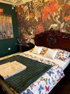a bedroom with a bed with a painting on the wall at Cracow. Villa Cherubin Garden in Kraków