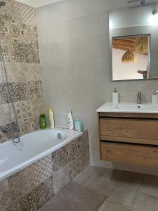 ein Badezimmer mit Badewanne und Waschbecken in der Unterkunft House of flowers in Mures