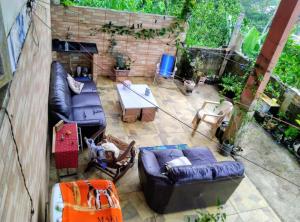 een terras met banken en een tafel bij há uma bela casa in Ubatuba